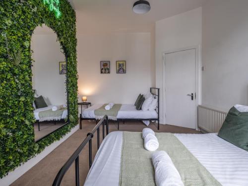 a bedroom with two beds and a green wall at Large Group Central Apartment in Newcastle upon Tyne