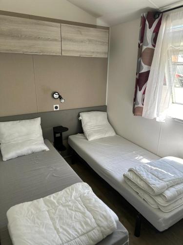 une chambre avec deux lits et une fenêtre dans l'établissement Camping Mar Estang, à Canet