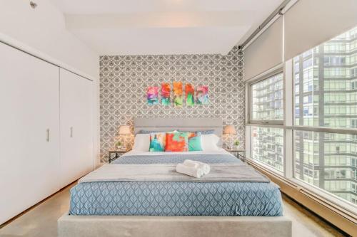 - une chambre avec un grand lit et de grandes fenêtres dans l'établissement Luxury 2BR Condo - King Bed - Stunning City Views, à Calgary