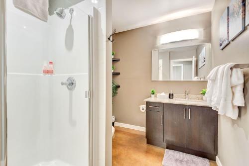 ein Bad mit einem Waschbecken und einem Spiegel in der Unterkunft Modern 2BR Condo - King Bed - Downtown City Views in Calgary