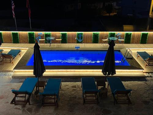 uma piscina com cadeiras e guarda-sóis em frente em Hotel Two Mermaids Ksamil em Ksamil