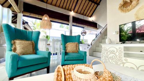 sala de estar con 2 sillas azules y mesa en Frangipani Villa Seminyak, en Seminyak