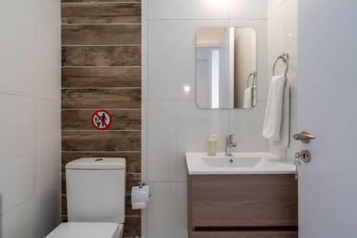 a bathroom with a white toilet and a sink at Moon Light 1-Bedroom Apartment in Larnaca in Larnaka