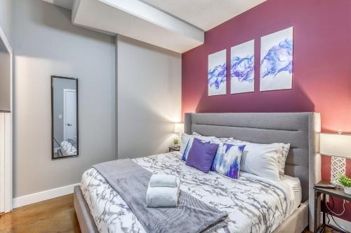 een slaapkamer met een groot bed met paarse muren bij Cozy 2BR Condo with King Bed and City Views in Calgary
