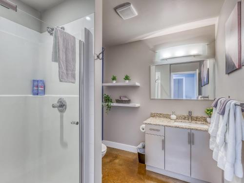 uma casa de banho com um lavatório e um espelho em Cozy 2BR Condo with King Bed and City Views em Calgary