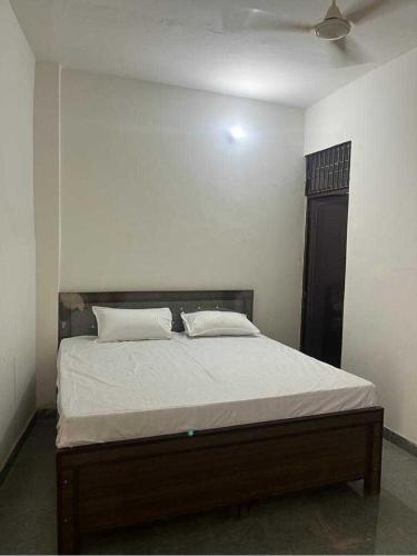 een slaapkamer met een groot bed met witte lakens bij OYO Home R K Oyo Hotel in Noida