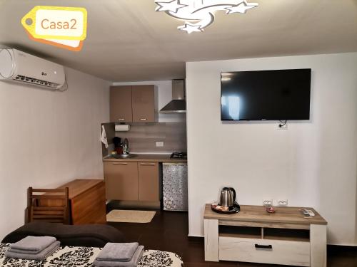 ein Wohnzimmer mit einem Sofa und einem TV an der Wand in der Unterkunft Casa Dașoveanu in Sulina