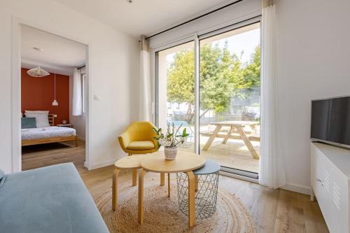 a living room with a table and a large window at Ar Mor, votre pied à terre cocoon au cœur de ville in Paimpol