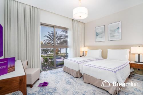 a hotel room with two beds and a window at Dream Inn - Address Beach Residence - Free Beach Access in Fujairah