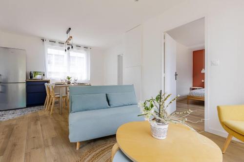 a living room with a blue couch and a table at Ar Mor, votre pied à terre cocoon au cœur de ville in Paimpol
