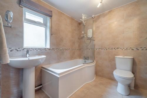 a bathroom with a toilet and a sink and a bath tub at Number One in Chapel Stile