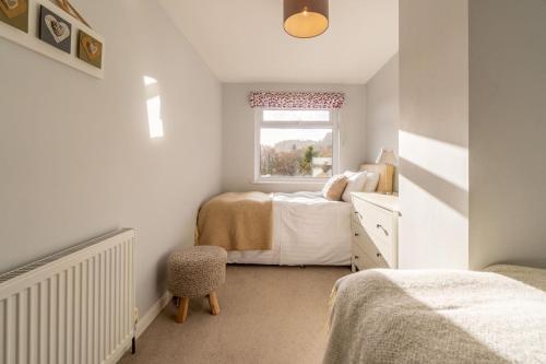 a small bedroom with two beds and a window at Number One in Chapel Stile