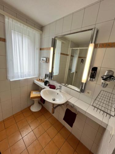 Hotel Alfa Superieur - Leukerbad-Therme في لوكرباد: حمام مع حوض ومرآة