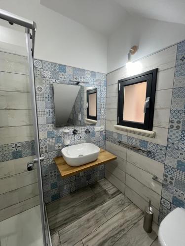 W łazience znajduje się umywalka i lustro. w obiekcie Perla Marina w mieście Realmonte