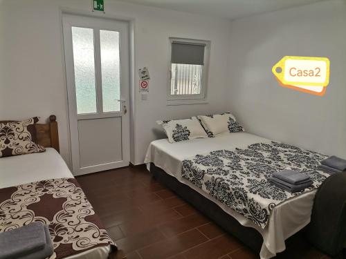 a bedroom with two beds and a window and a door at Casa Dașoveanu in Sulina
