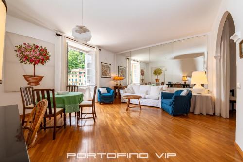 ein Wohnzimmer mit einem Tisch und blauen Stühlen in der Unterkunft Your Window on Portofino by PortofinoVip in Portofino