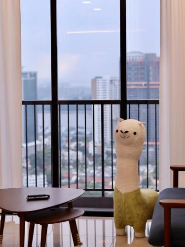 a stuffed cat sitting in front of a window at Twin Tower Residence by Nest Home【5 mins walk to CIQ】 in Johor Bahru