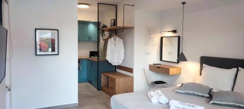 1 dormitorio con cama, lavabo y espejo en Cove Suites en Iraklitsa