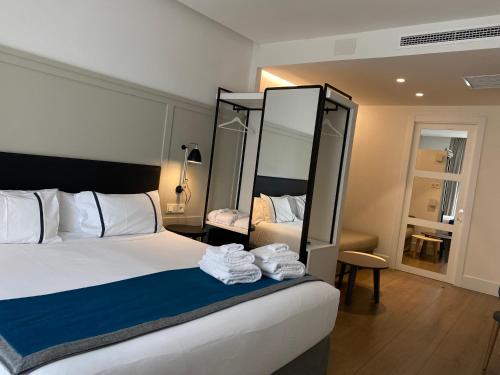 a hotel room with a bed and a mirror at Hotel SANSEbay in Donostia-San Sebastián
