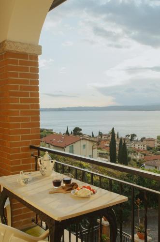 a table on a balcony with a view of the ocean at Villa Maria Lake View,7 minuti a piedi dal centro, parcheggio privato in Torri del Benaco