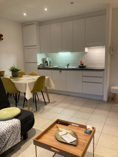 a living room with a table and a kitchen at DUNAS, appartement, garage, 200m van strand en centrum in Koksijde