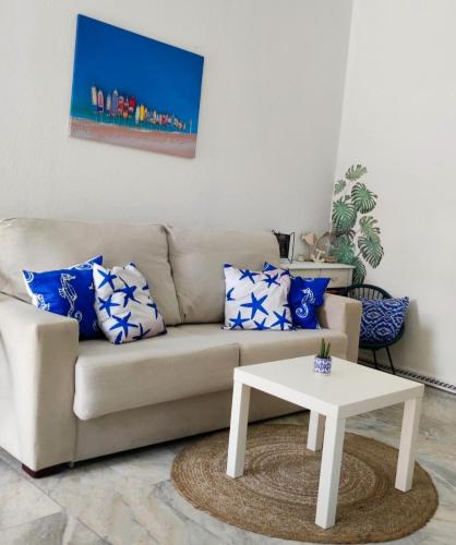 uma sala de estar com um sofá e uma mesa em Apartamentos home Chipiona em Chipiona