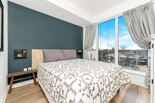 een slaapkamer met een bed en een groot raam bij Stylish Downtown - 1BR Condo - Superb Views in Kitchener