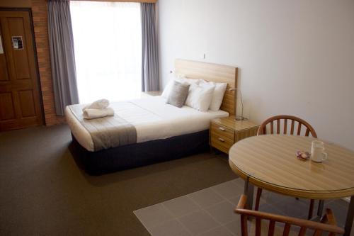 a hotel room with two beds and a table at Albury Paddlesteamer Motel in Albury