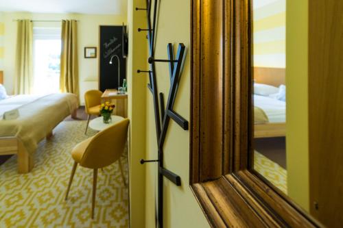 a hotel room with a mirror and a bedroom at Das Eisenberg in Sankt Martin an der Raab