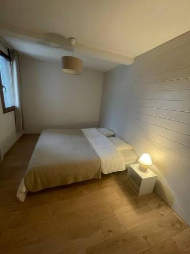 - une petite chambre avec un lit et une lampe dans l'établissement Charmant appartement avec terrasse, à Arreau