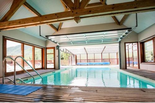 une grande piscine intérieure avec fenêtres dans l'établissement Charmant appartement avec terrasse, à Arreau