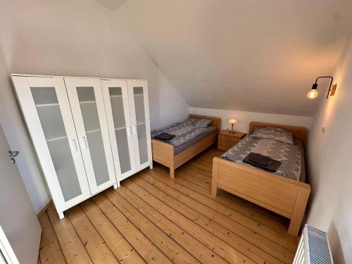 a bedroom with two beds and a closet at Idyllisches Zechenhaus, auch geeignet als Monteurenwohnung in Essen
