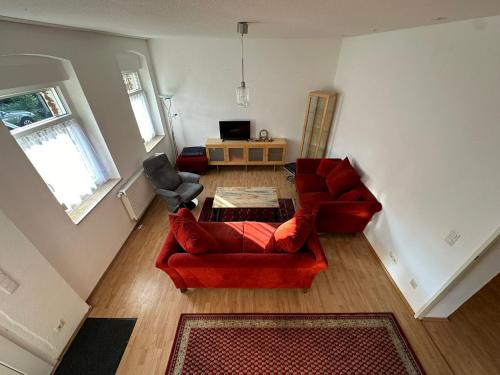 a living room with two red chairs and a table at Idyllisches Zechenhaus, auch geeignet als Monteurenwohnung in Essen