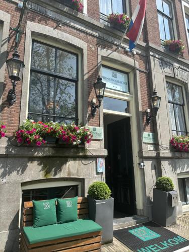 a bench in front of a building with flowers at Prinsengracht Hotel in Amsterdam