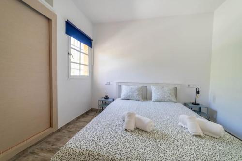 una camera da letto con un grande letto con due cuscini sopra di Sol y mar maspalomas a Maspalomas