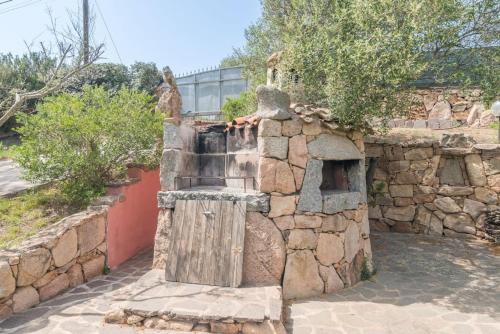 a stone wall with a fountain in front of it at Luxury Home in Porto Rotondo in Cugnana