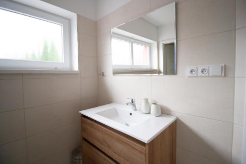 a bathroom with a sink and a mirror at Penzion Anebel in Luhačovice