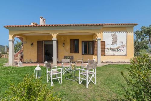 a house with a table and chairs in the yard at Luxury Home in Porto Rotondo in Cugnana