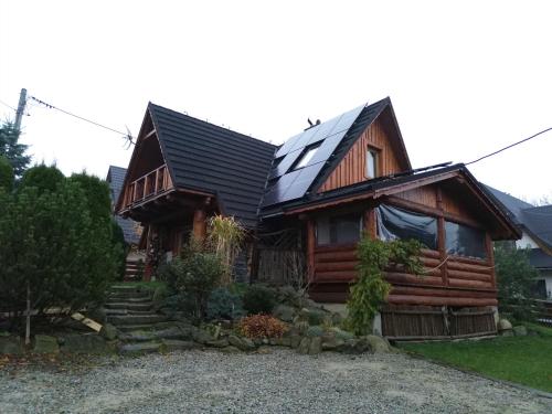 a house with a solar roof on top of it at Domki Majerczykówka 29a in Poronin