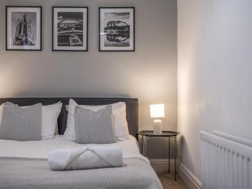 - une chambre dotée d'un lit avec 4 photos sur le mur dans l'établissement Spacious City Sanctuary, à Newcastle upon Tyne