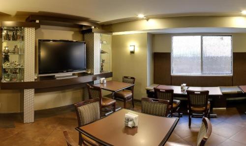 a restaurant with tables and chairs and a flat screen tv at Hotel Strata in Mountain View
