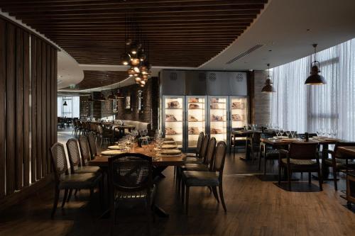 a dining room with tables and chairs in a restaurant at Concorde Tower Hotel & Casino in North Nicosia