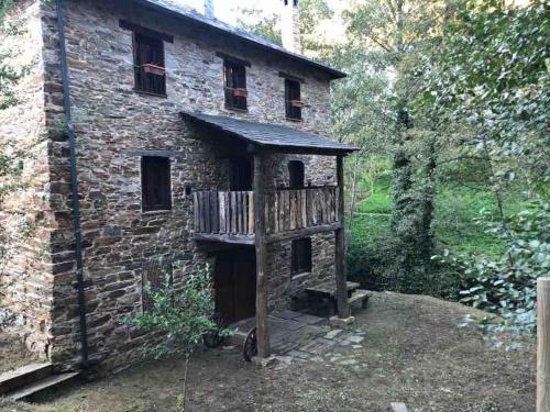 a brick building with a wooden deck in front of it at O Recuncho de Doiras in Ferreiravedés