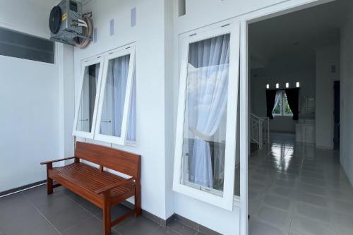 a wooden bench sitting in a room with windows at RedDoorz at Griya Martha Sumber Solo in Bonorejo