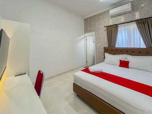 a bedroom with a large bed and a window at RedDoorz at Griya Martha Sumber Solo in Bonorejo