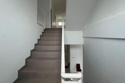 a staircase in a building with a stair case at RedDoorz at Griya Martha Sumber Solo in Bonorejo