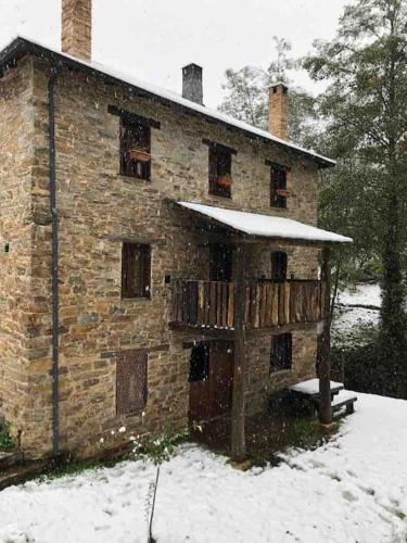 an old brick building with snow on it at O Recuncho de Doiras in Ferreiravedés