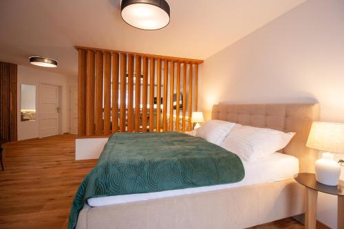 Un dormitorio con una cama con una manta verde. en Penzion Anebel en Luhačovice