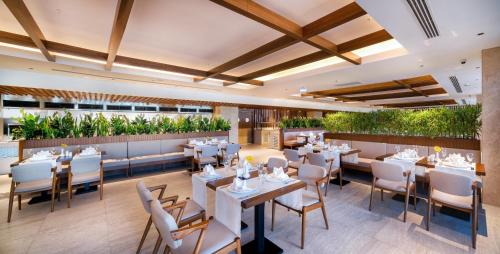 a restaurant with tables and chairs and plants at Concorde Tower Hotel & Casino in North Nicosia