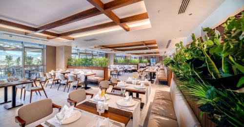 a restaurant with tables and chairs and plants at Concorde Tower Hotel & Casino in North Nicosia